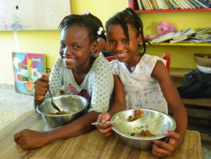 Two smiling Haiti girls with their meals