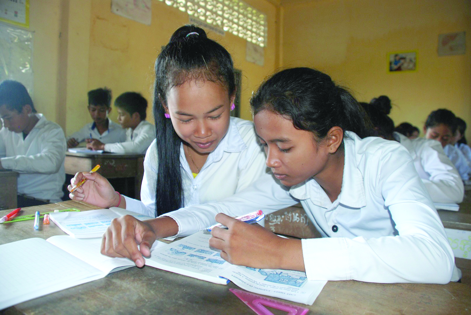 Two students studying together in a classroom.