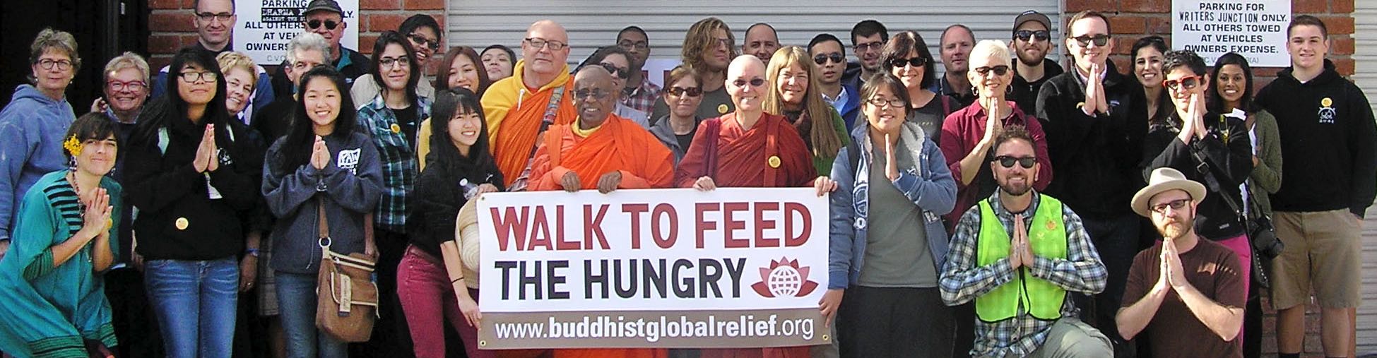 Group of diverse people holding a banner for a hunger relief walk.
