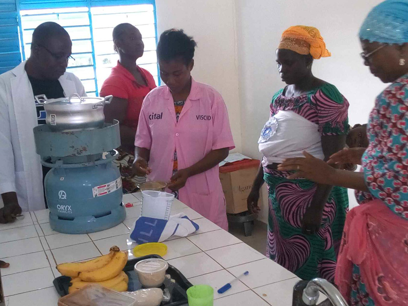 Women preparing food together in a kitchen setting.