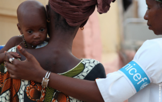 A woman from the Horn of Africa is holding her kid with the helping hand from BGR partner UNICEF