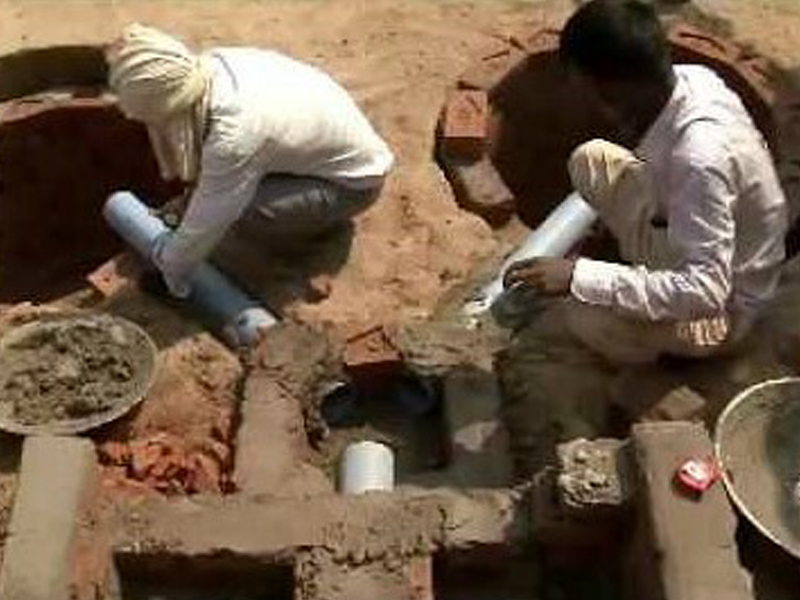 Two men are working on the ground for the pipe system