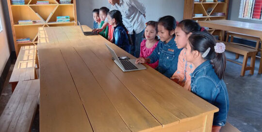 A group of children and a teacher engaged in a classroom activity with tablets.