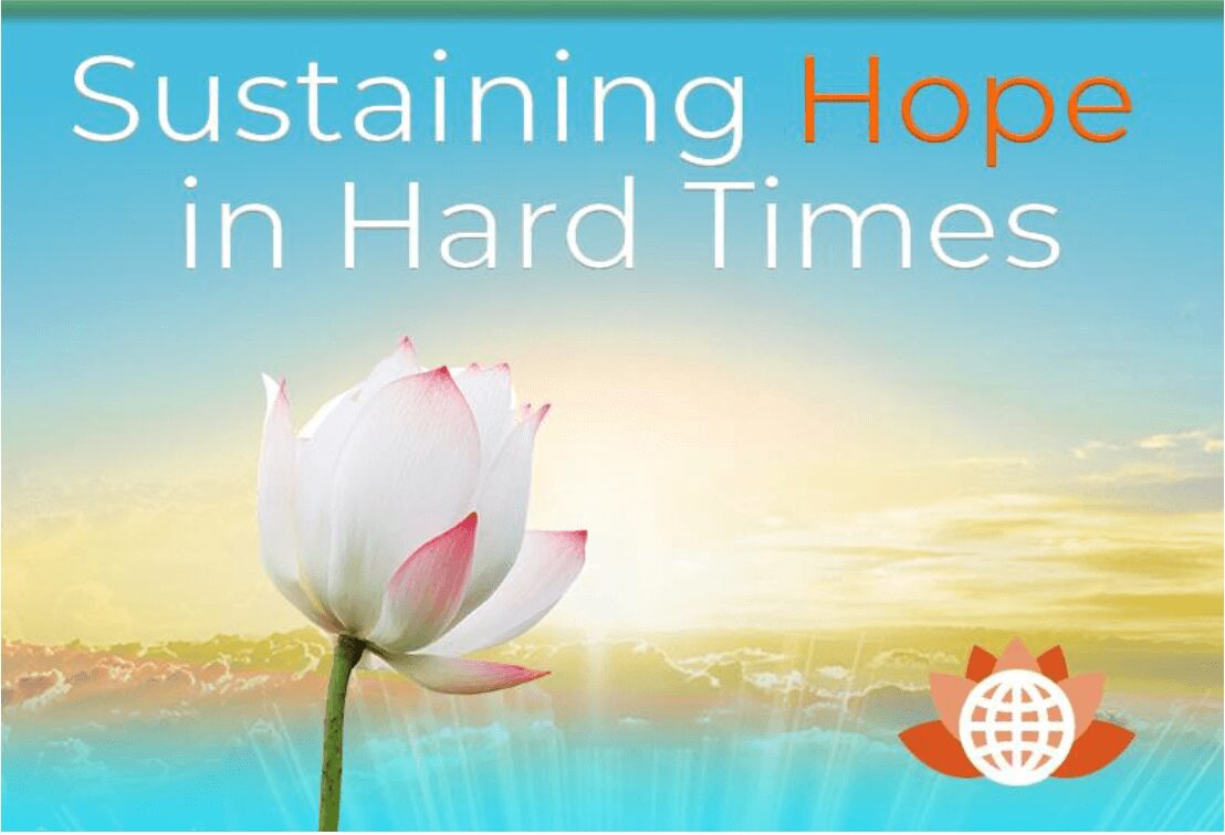 A white lotus flower with pink tips under a hopeful sunrise sky.