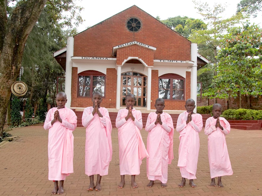 Group of women in pink dresses standing in front of a church.